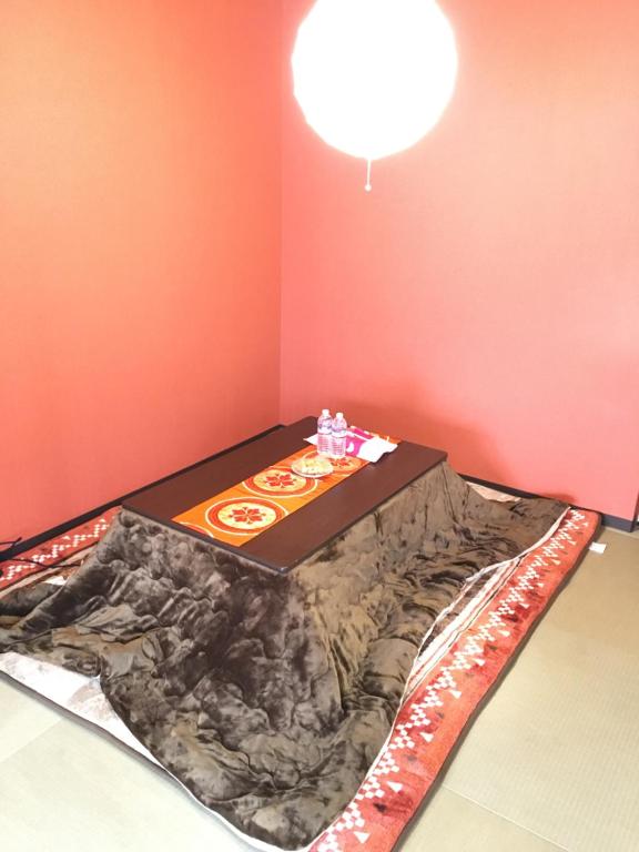 Bett in einem Zimmer mit einem Ecktisch in der Unterkunft Yukiya in Osaka