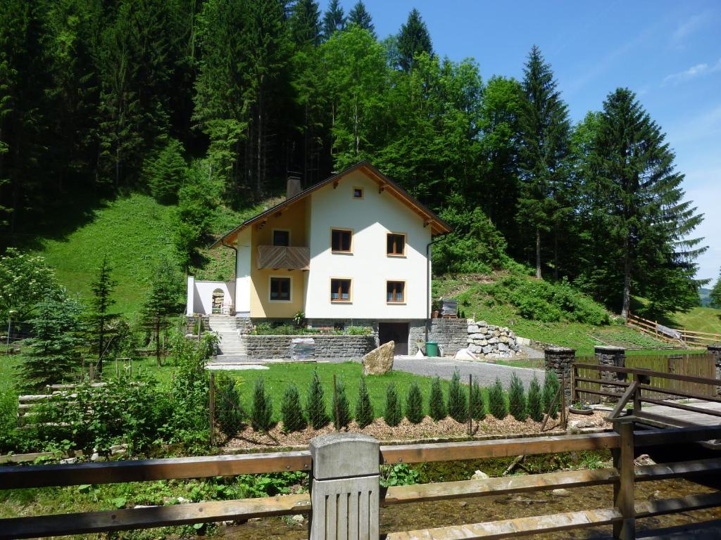 uma casa no lado de uma colina com uma cerca em Gästehaus Forstner em Loich