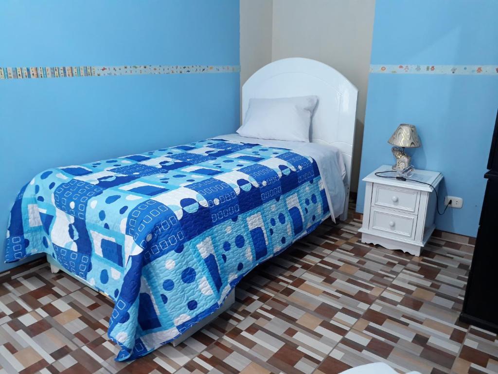 a blue bedroom with a bed and a nightstand at B&B La Casa del Turista in Lima