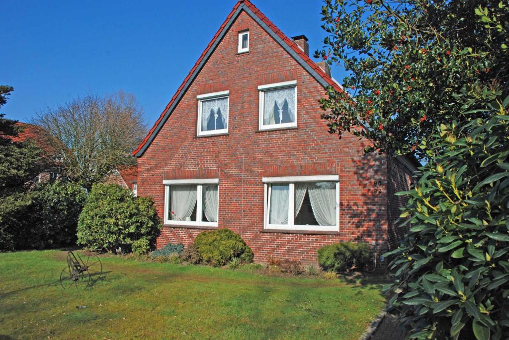 a red brick house with three windows on it at Appartements im Moormerland in Warsingsfehn