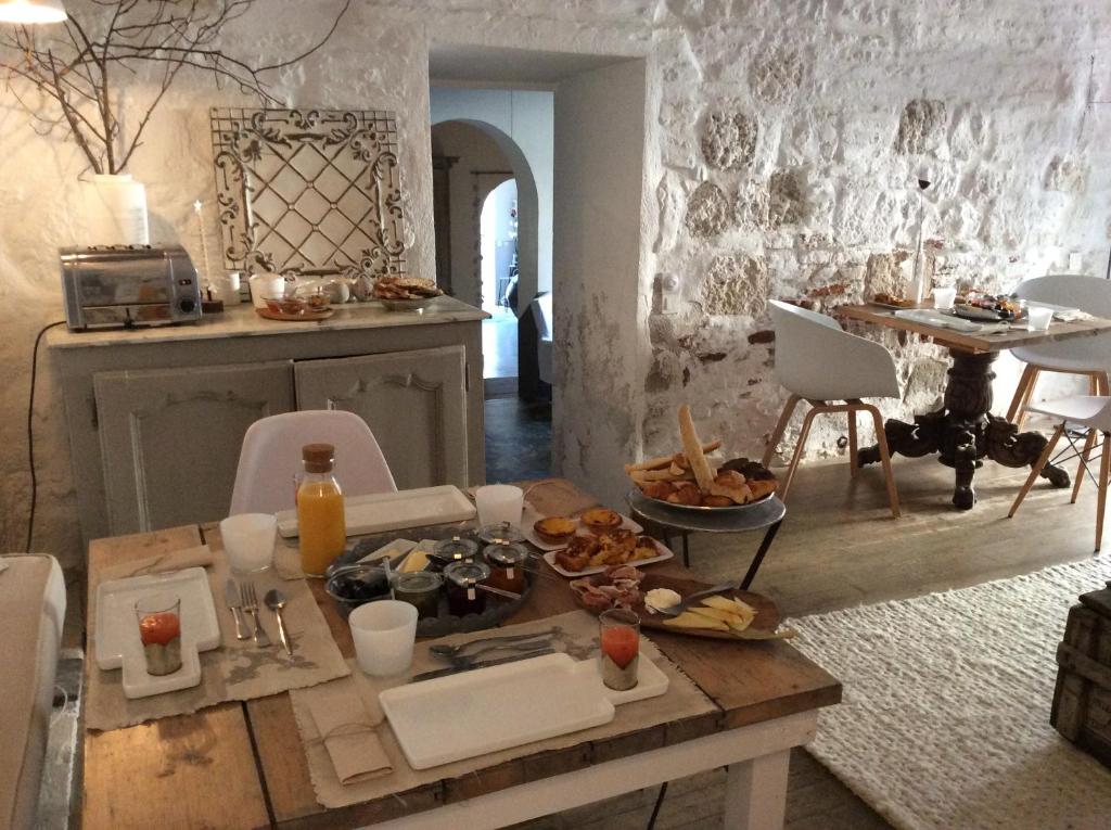 een kamer met een tafel met eten erop bij La maison sur la place in Penne-dʼAgenais