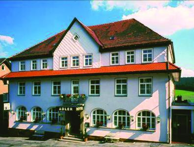 a large white house with a red roof at Hotel Adler in Sankt Georgen im Schwarzwald