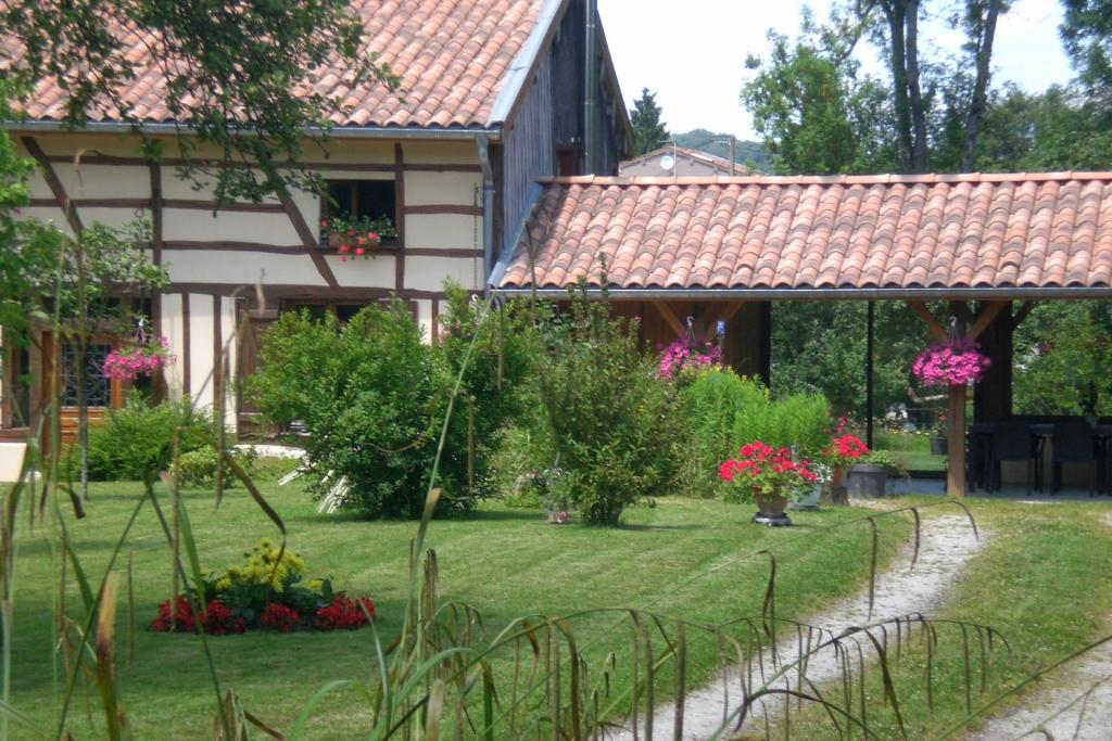 un jardin avec des fleurs en face d'une maison dans l'établissement La maison du bûcheron, à Futeau