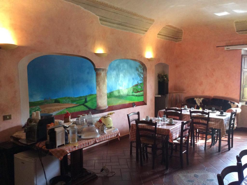 restauracja ze stołami i krzesłami oraz obrazem na ścianie w obiekcie B&B e Locazioni Turistiche Antico Borgo Toscano w Montecatini Terme