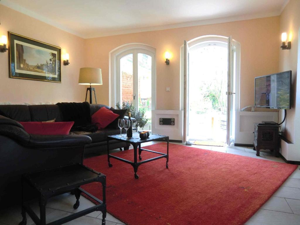 sala de estar con sofá y alfombra roja en maisonette, en Teltow