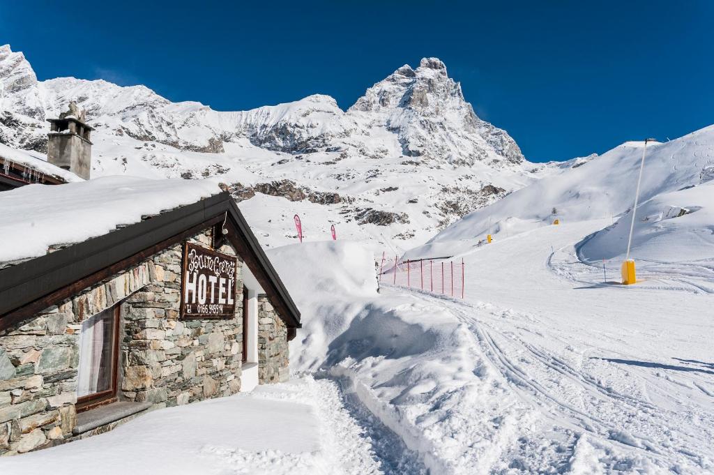 ein Gebäude im Schnee mit einem Berg in der Unterkunft Hotel Baita Cretaz in Breuil-Cervinia