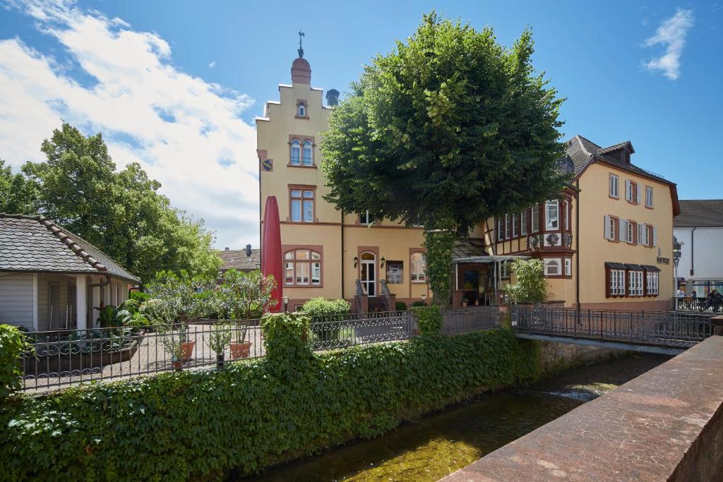 un edificio con un río delante de él en Badischer Hof, en Bühl