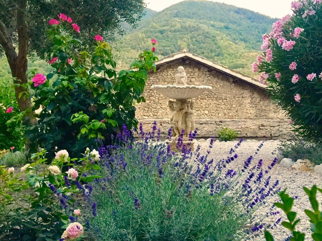 a fountain in the middle of a garden with flowers at Palazzo Sant'Angelo in Spoleto