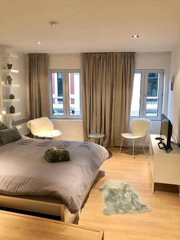 een slaapkamer met een bed, een bureau en een stoel bij Your suite Ghent in Gent