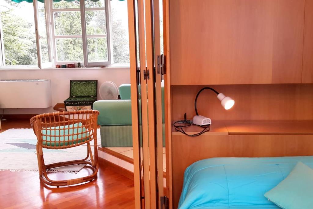 una camera con letto, sedia e finestra di Park apartment a Bellagio