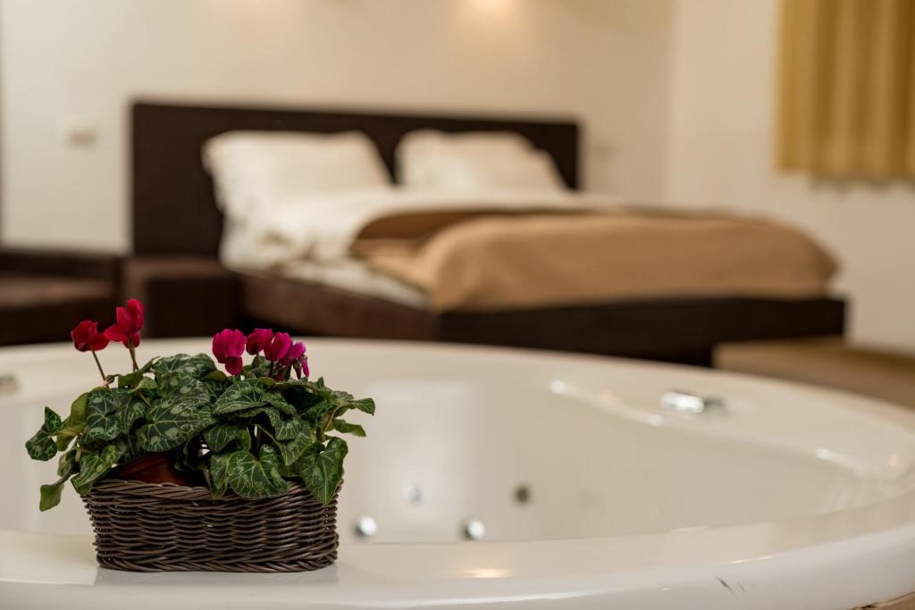 a bathroom with a white bath tub with a basket of flowers at Nofey Habashan in Lahavot HaBashan