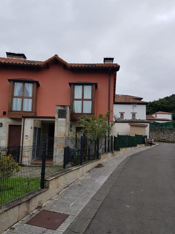 a house with a fence in front of a street at nueva el bosquin in Nueva de Llanes