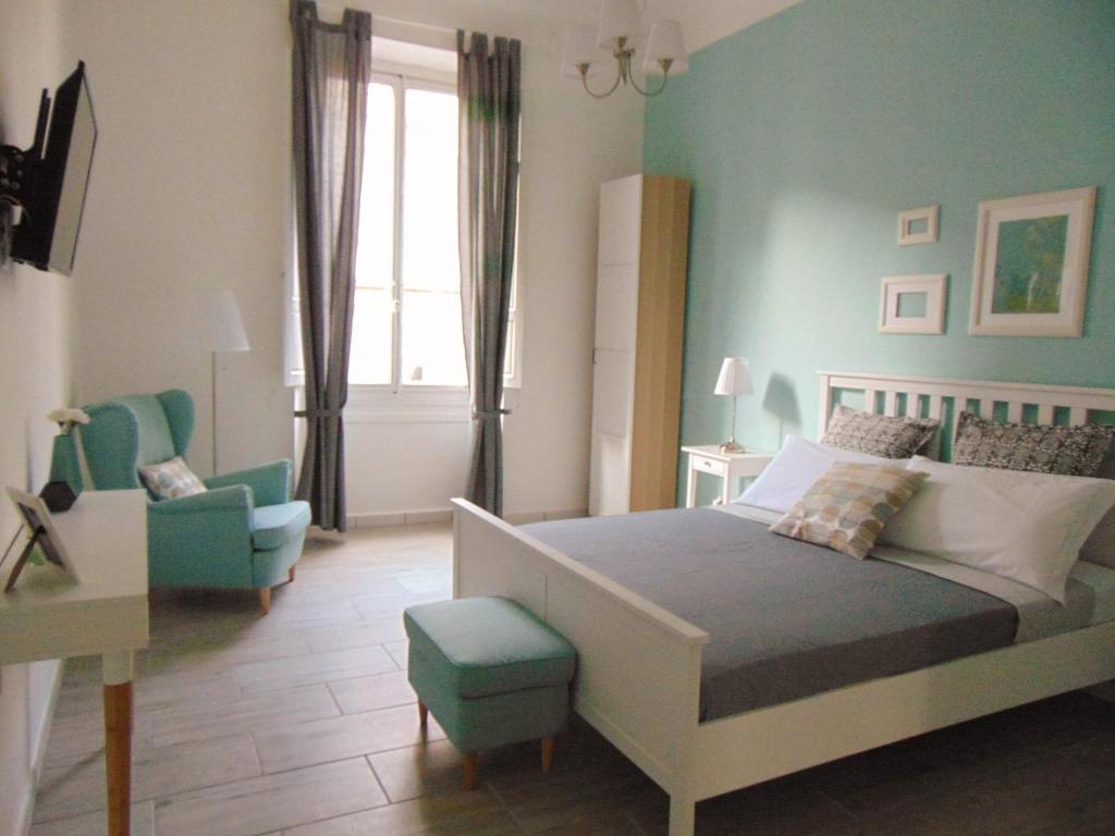ein Schlafzimmer mit einem Bett, einem Stuhl und einem Fenster in der Unterkunft Lost In Florence in Florenz