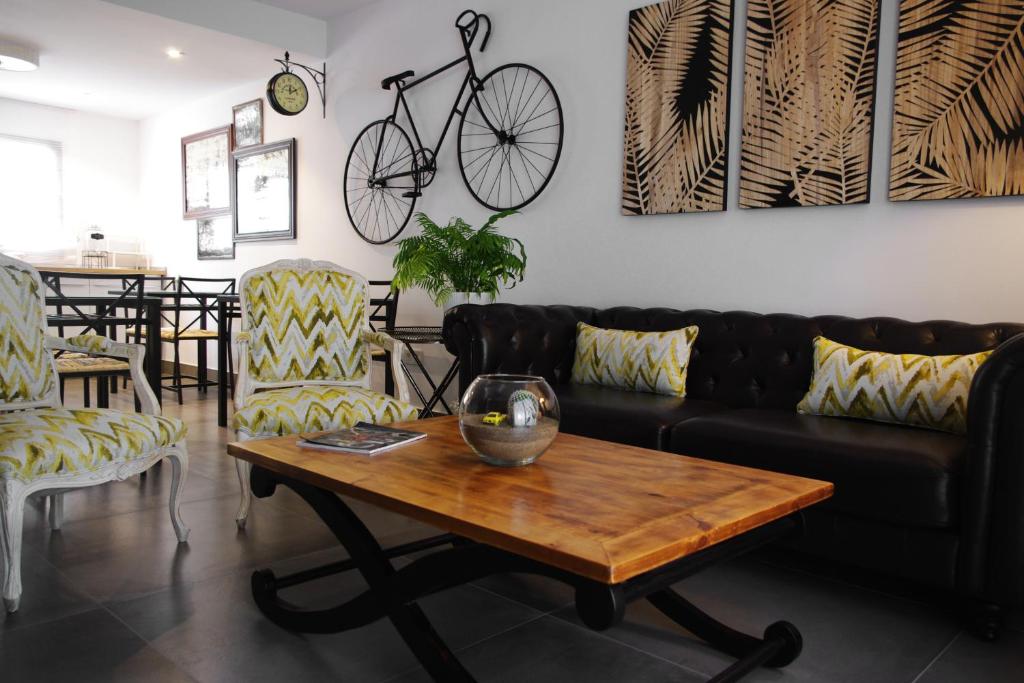 a living room with a couch and a table and a bike on the wall at MAGMA Rooms Playa Honda in Playa Honda