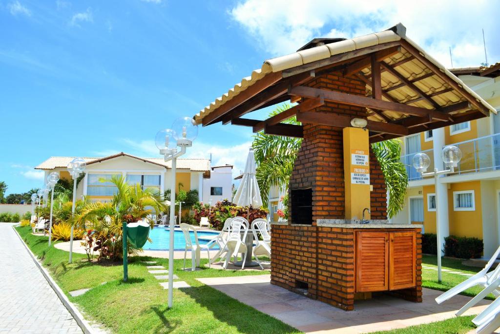 a barbecue grill in a yard next to a house at Casa Carmelo #18 in Porto Seguro