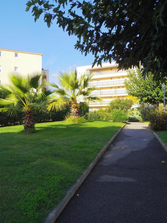 um parque com palmeiras em frente a um edifício em Charmant T2 Lagon Bleu em Fréjus