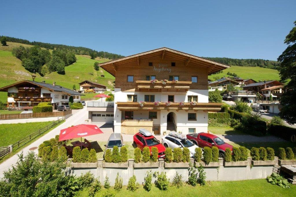 a house with cars parked in front of it at Gästehaus Ingeborg in Saalbach-Hinterglemm