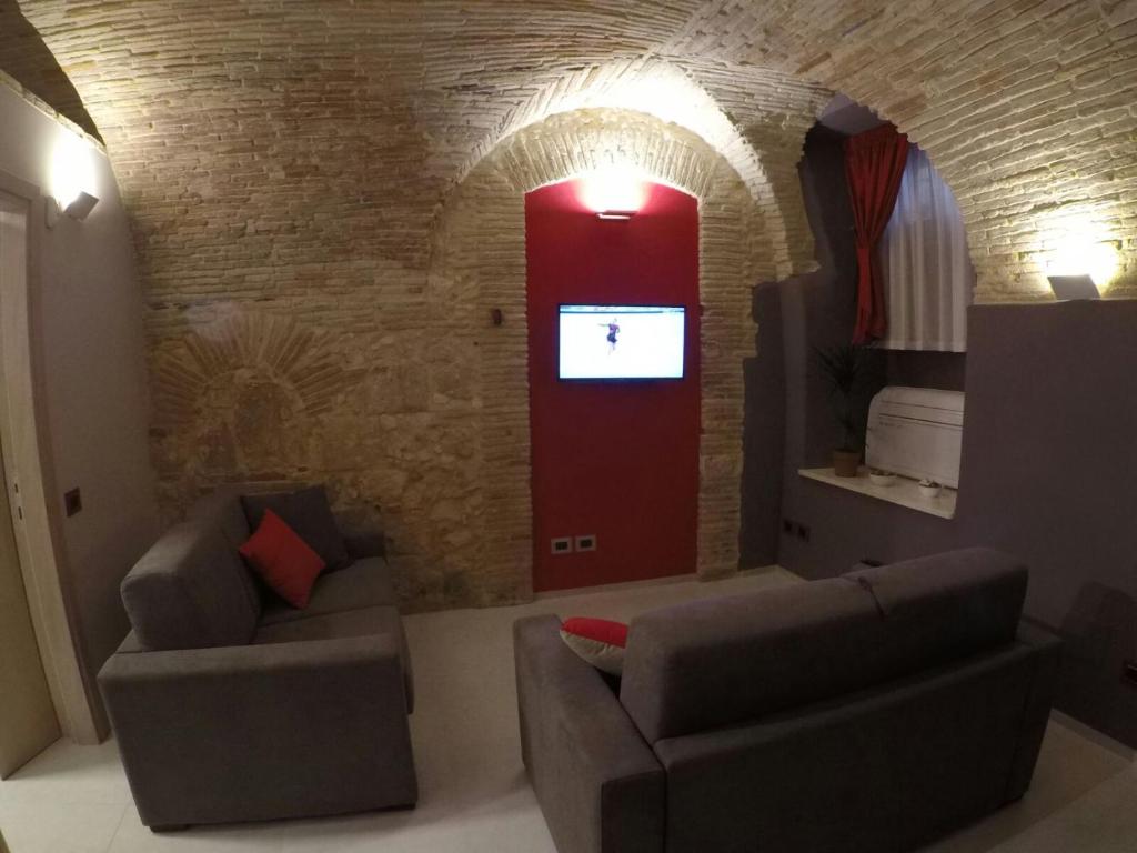 un soggiorno con 2 divani e una porta rossa di Al Castello a Cagliari