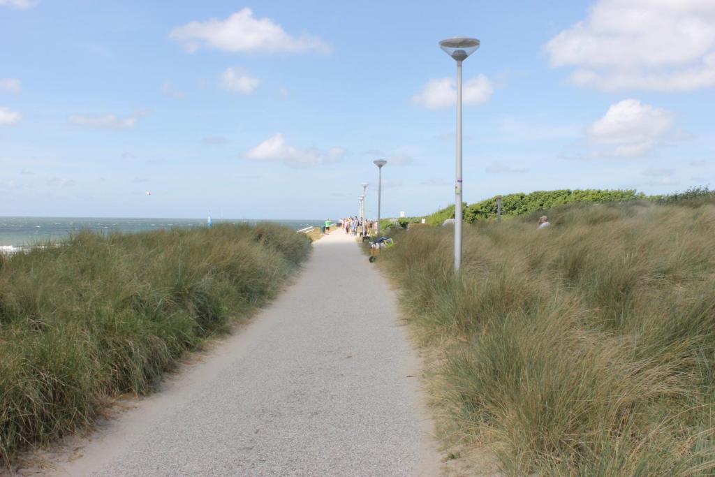 a dirt path with lights on the side of a beach at Zon Zee Zoutelande in Zoutelande