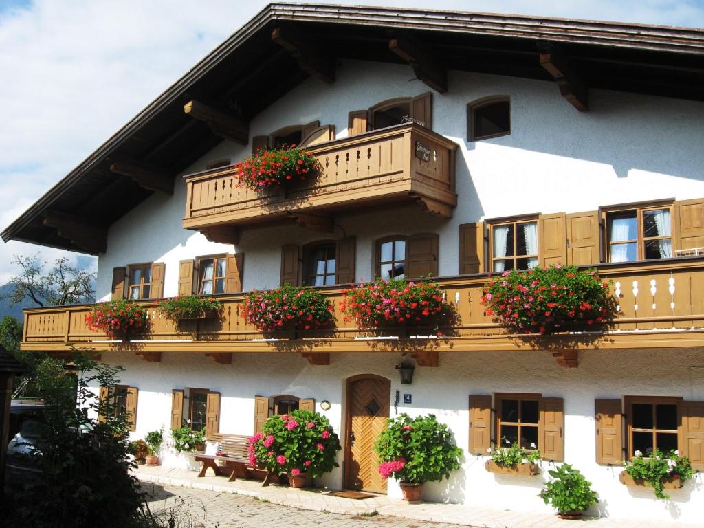 een gebouw met potplanten op de balkons bij Haus Schmiederer in Reit im Winkl