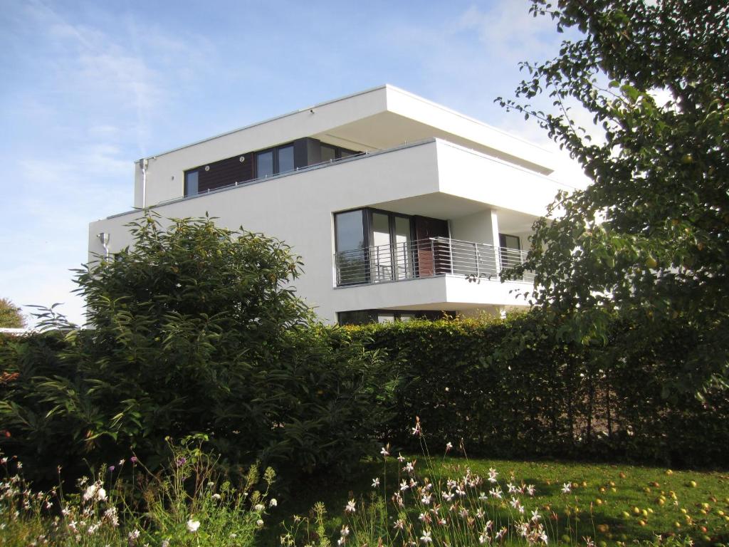 ein weißes Haus mit Balkon auf einem Hügel in der Unterkunft Ferienwohnung Sundblick in Altefähr