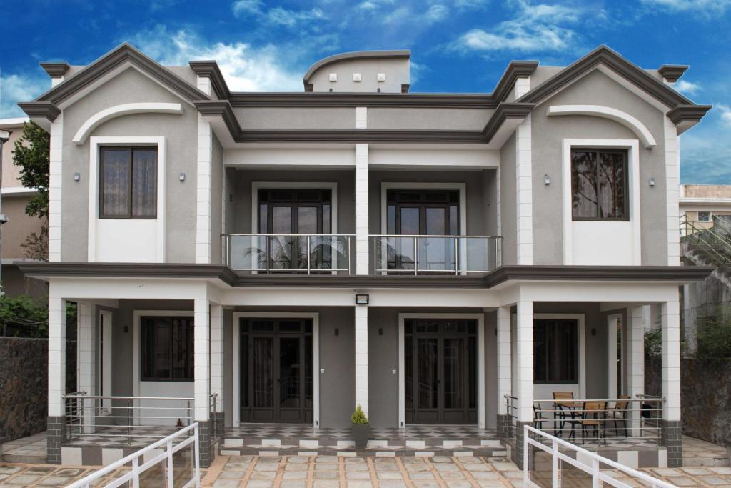 a large white house with a balcony at Fantasea Villa - Mont Choisy in Mont Choisy