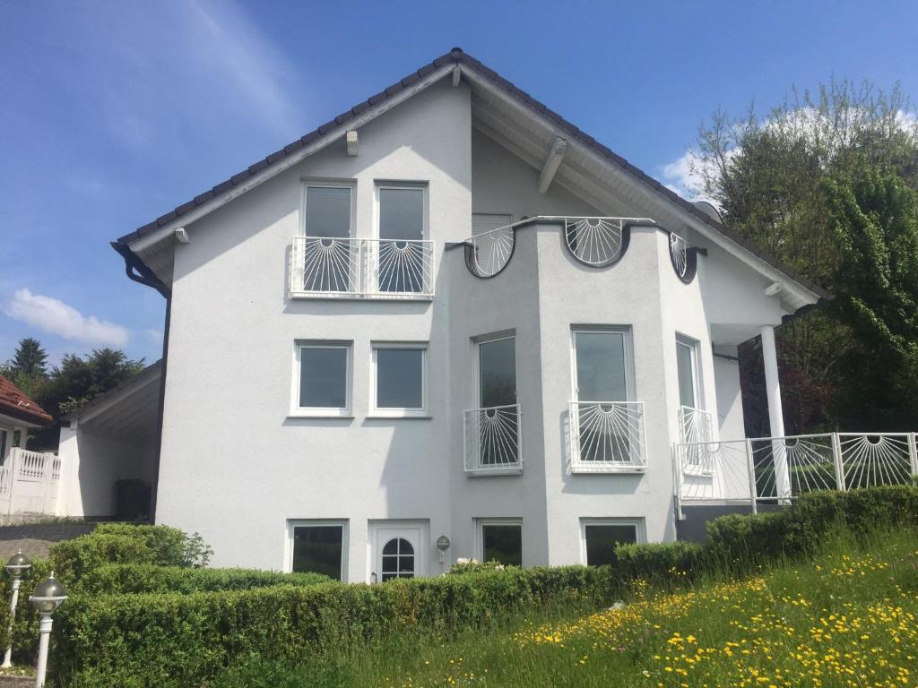 Una casa blanca con balcones en un lateral. en Wohlfühl-Apartment Bergwinkel, en Schlüchtern