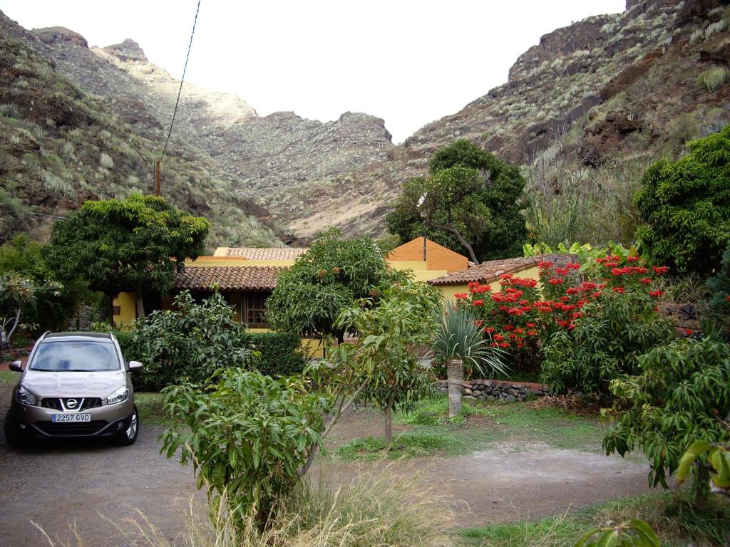 un'auto parcheggiata in un parcheggio di fronte a una casa di Casa Dos Barrancos a Santa Cruz de Tenerife