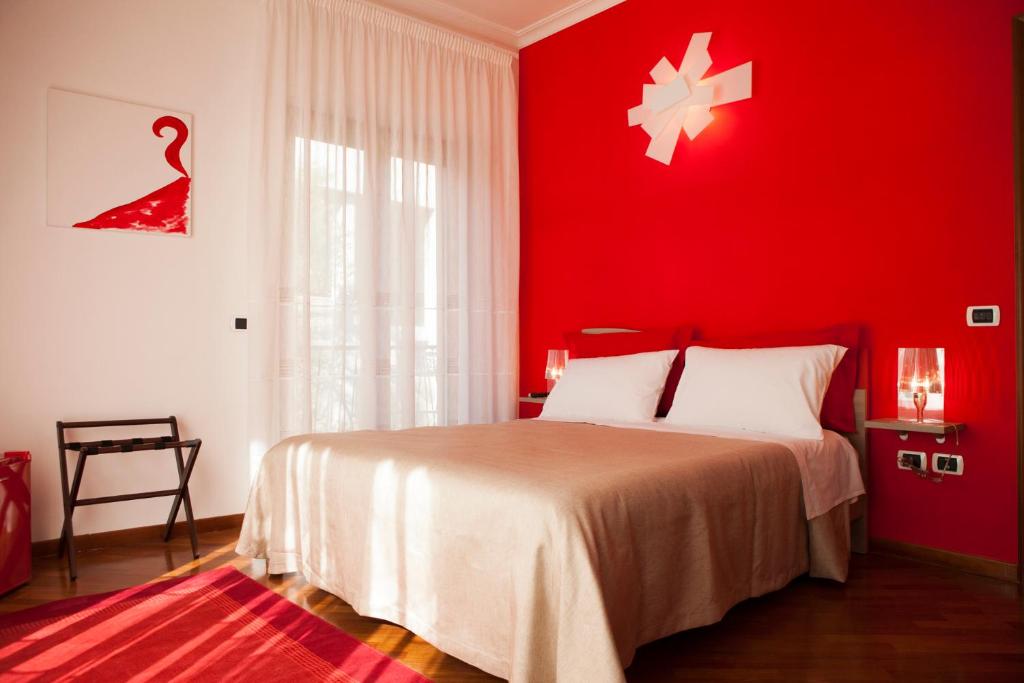 um quarto vermelho com uma cama e uma parede vermelha em Isa Guest Rooms em Nápoles