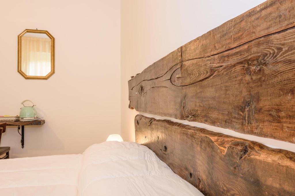 ベルガモにあるMaison Al Parcoのベッドルーム(木製ヘッドボード、ベッド付)