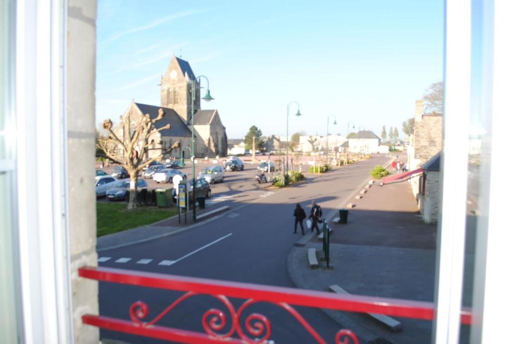 Elle offre une vue sur une rue de la ville depuis sa fenêtre. dans l'établissement Gite le Sainte Mère Eglise, à Sainte-Mère-Église