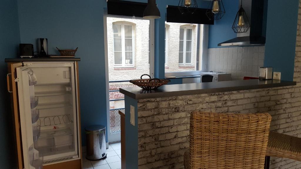 ディエップにあるAppartement Cosy au bord de merの青い壁のキッチン、カウンター(椅子付)
