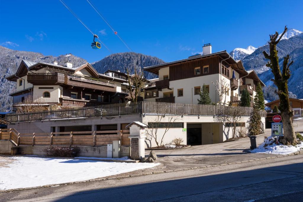 een huis aan de kant van een straat met bergen bij Am Eschenbichl in Mayrhofen