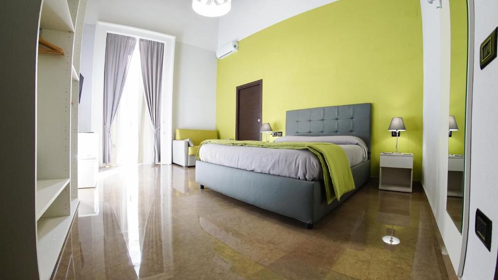 una camera con un letto e una parete gialla di Beverello Suite a Napoli