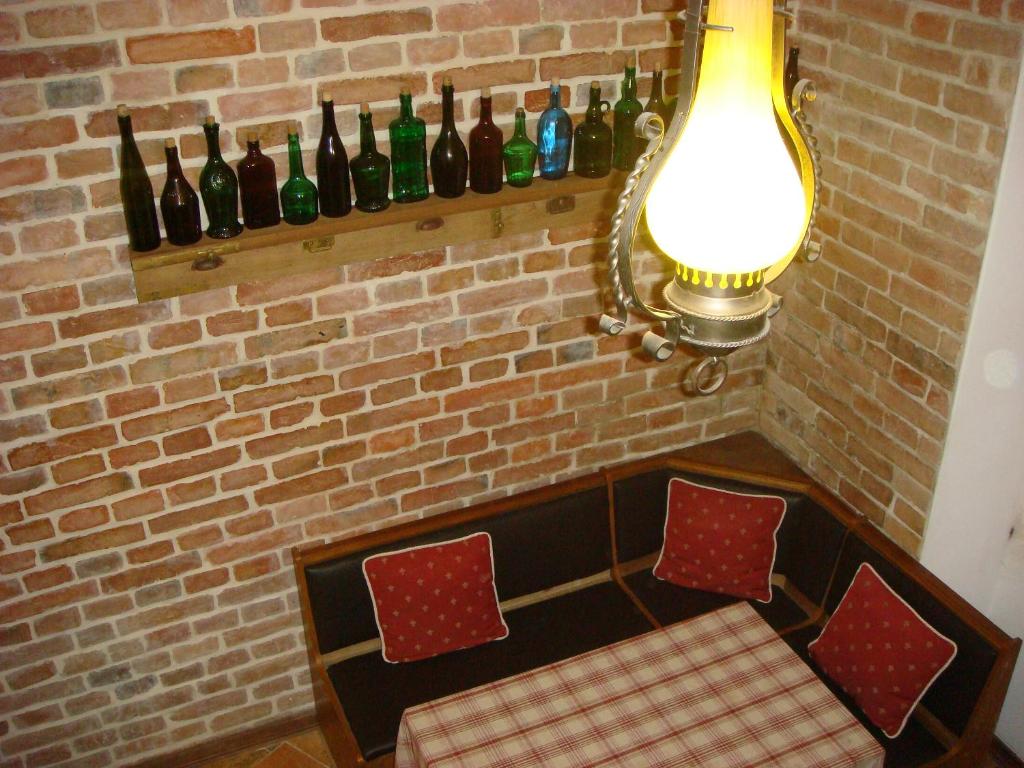 um quarto com uma parede de tijolos com garrafas de vinho numa prateleira em Kufer Flat em Lviv