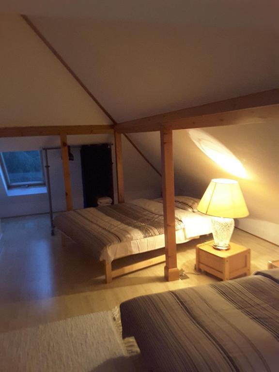 a bedroom with two beds and a lamp on a table at Osterley Studio Room in Isleworth