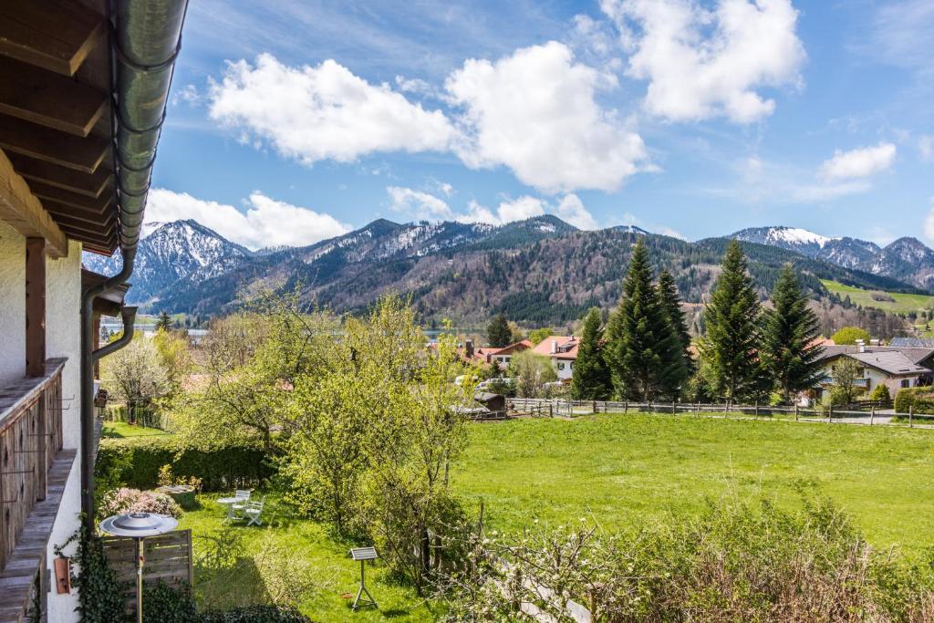 a view of a yard with mountains in the background at Ferienwohnung "Zum Leitnerbachl" in Schliersee