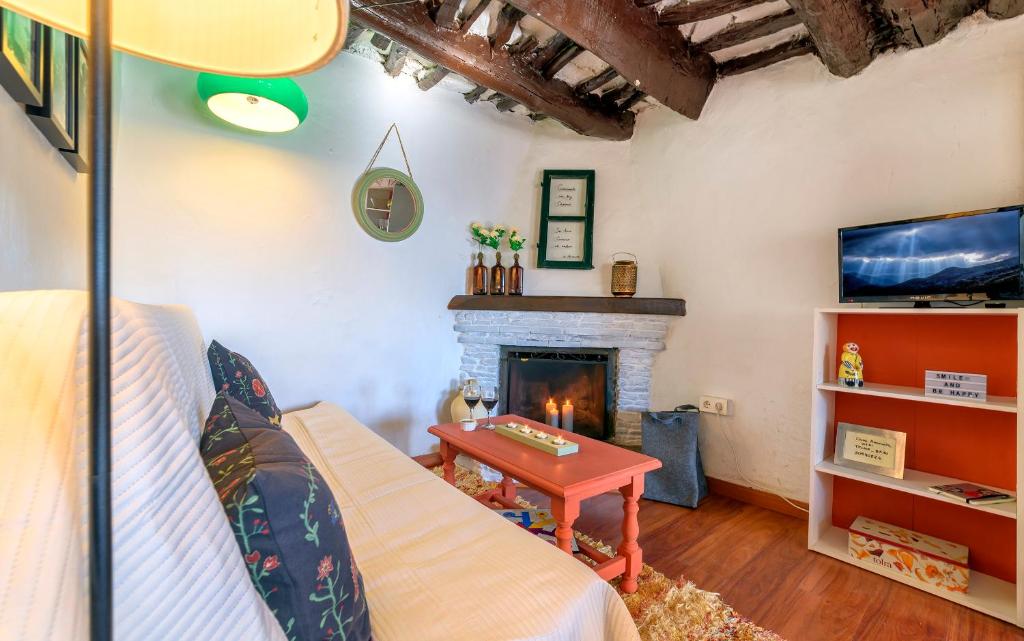 salon z kominkiem i kanapą w obiekcie Casa Amaranta w mieście Capileira