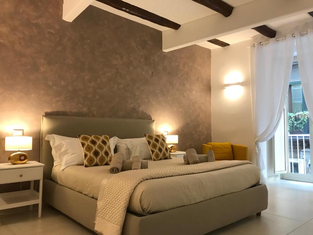 ナポリにあるNapoli Plebiscito Apartmentのベッドルーム1室(大型ベッド1台、黄色い枕付)