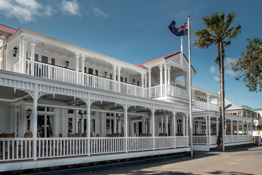 a white building with a palm tree and a flag at The Duke Of Marlborough in Russell