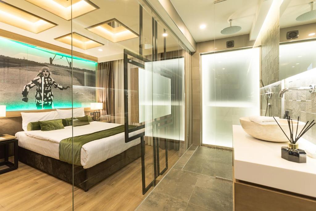 a bedroom with a bed and a glass wall at Eden Luxury Suites Terazije in Belgrade