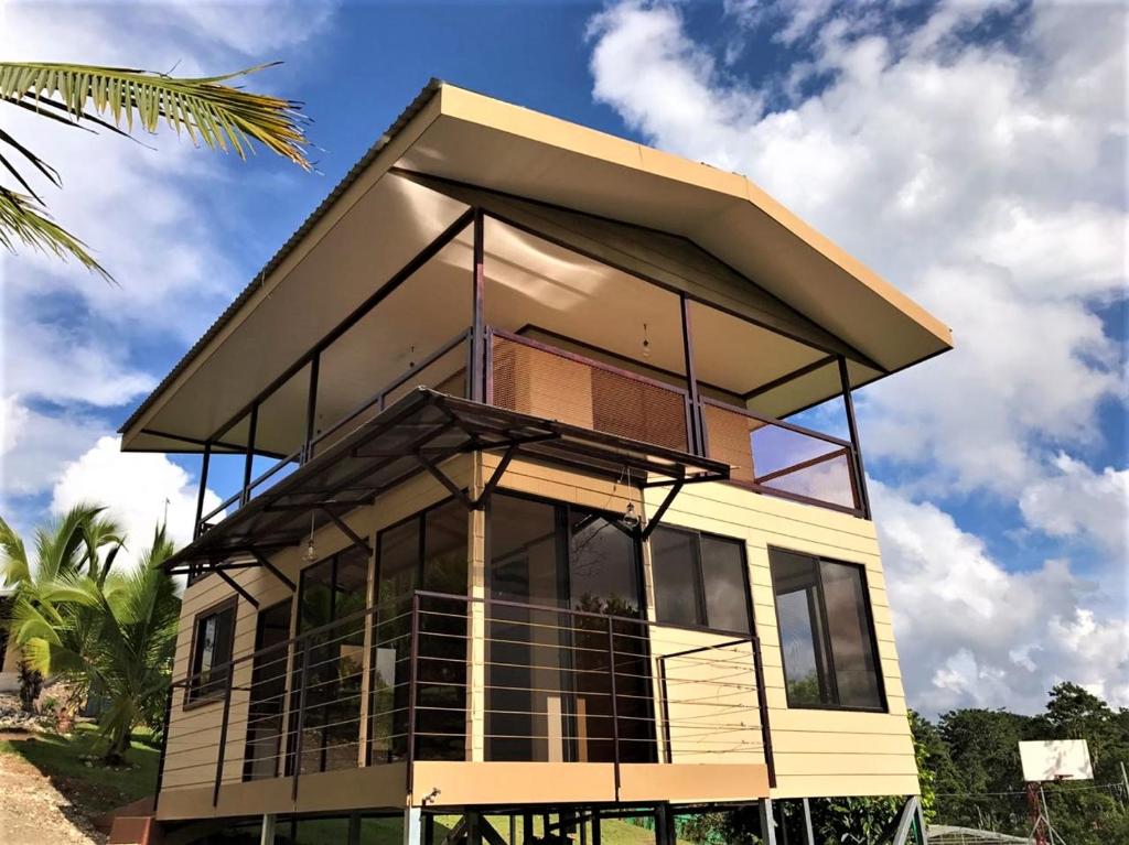 a house with a roof on top of it at Cabaña Amík'así in Turrialba