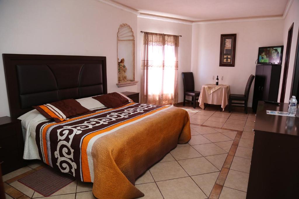 een slaapkamer met een groot bed en een tafel bij Casa Celia Hotel Restaurante in Bernal