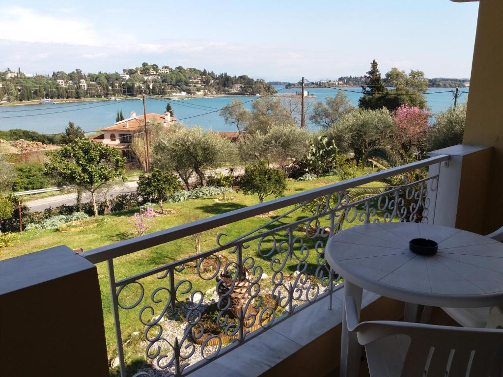 a balcony with a table and a view of the water at Athineos Apartments in Kommeno