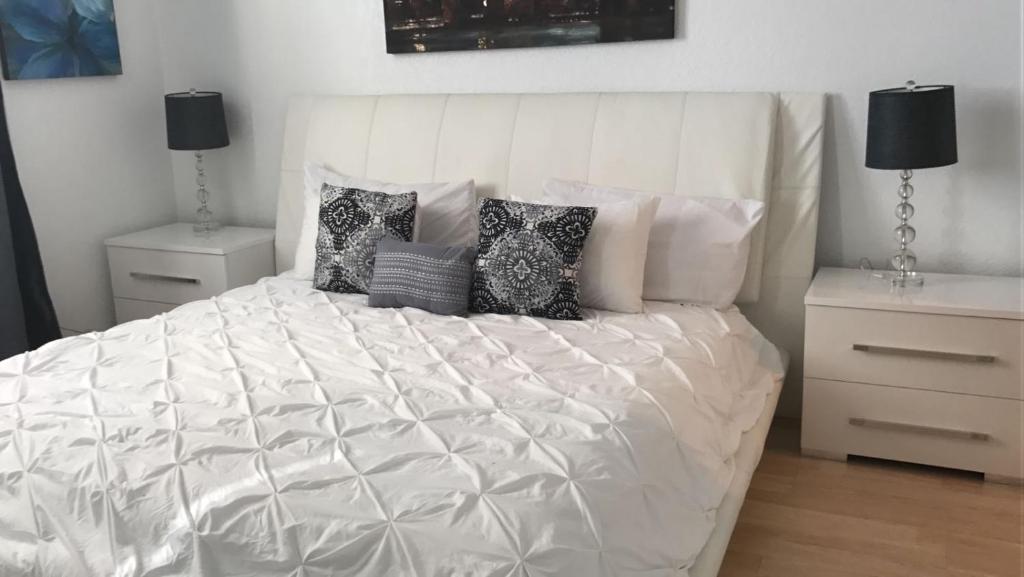 a white bed with pillows on it in a bedroom at Apartments at Sian Residences in Hollywood