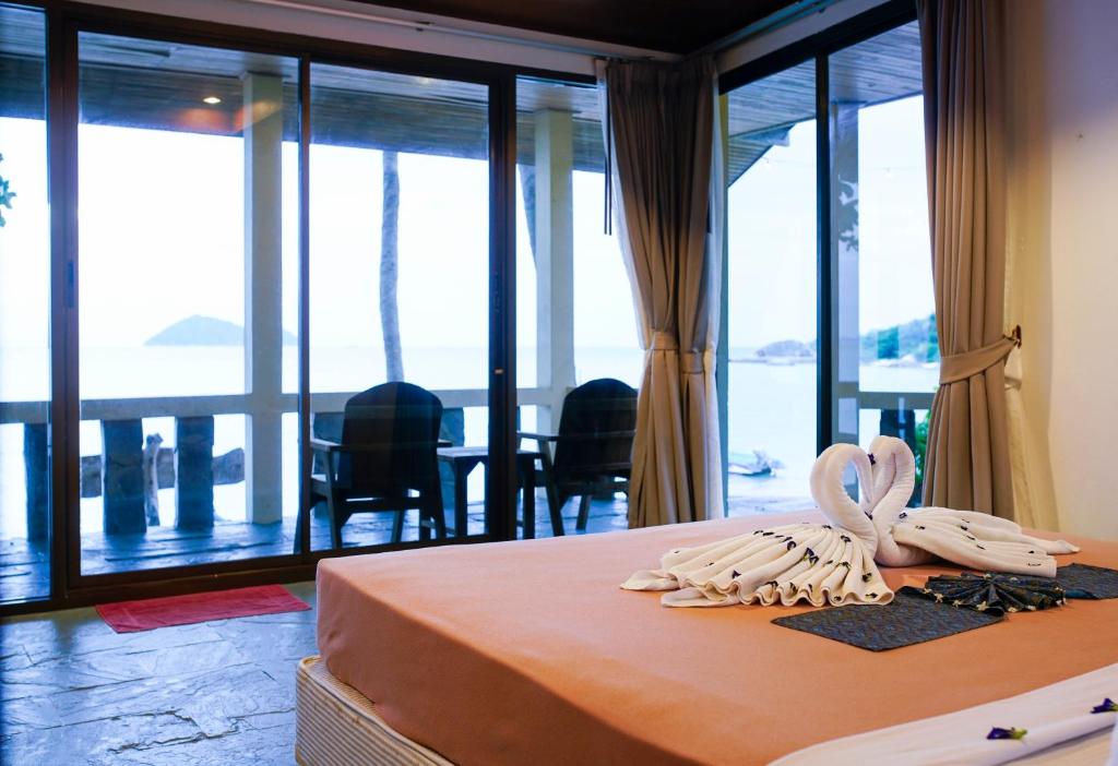 a bedroom with a bed with a view of the ocean at Beck's Resort in Haad Pleayleam