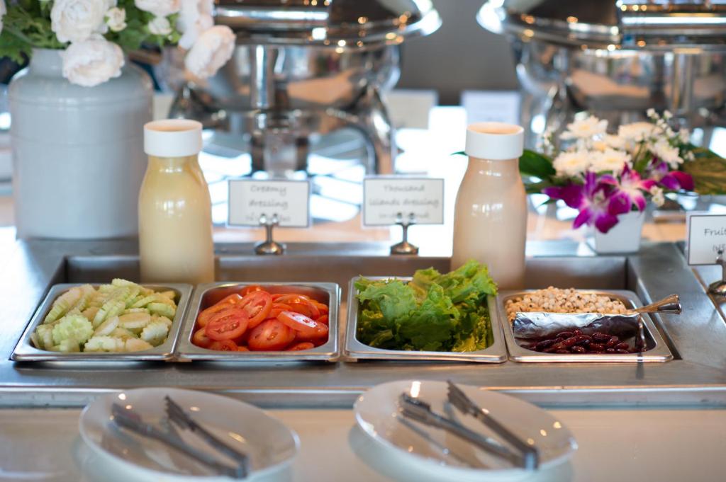 a buffet with plates of food and bottles of milk at Simplitel in Karon Beach