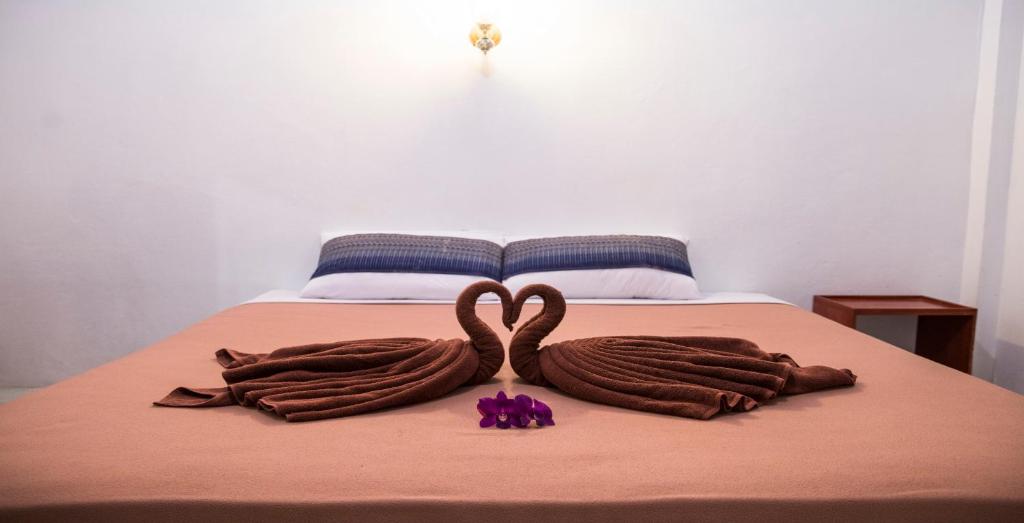 two swans made out of leather are on a bed at Beck's Resort in Haad Pleayleam