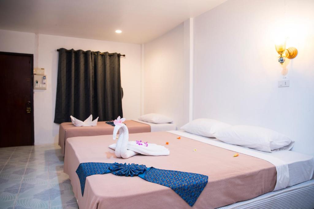 a hotel room with two beds with towels on them at Beck's Resort in Haad Pleayleam