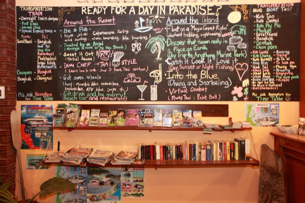 a chalkboard with a menu and a shelf of books at Beck's Resort in Haad Pleayleam